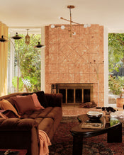 Living room with a brown sectional sofa covered with 100% French flax linen soft furnishings in terracotta, pink clay and cacao; plus a coffee table, and stone fireplace. - view