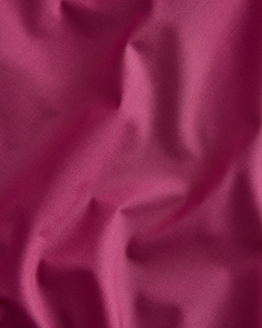 crumpled magenta fabric with soft folds and gentle shadows, creating a textured and subtly shiny look.