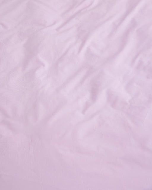 A close-up of the Violet 100% Organic Cotton Flat Sheet by Bed Threads, showing its light pink, breathable surface with gentle wrinkles, crafted from GOTS certified organic cotton percale.