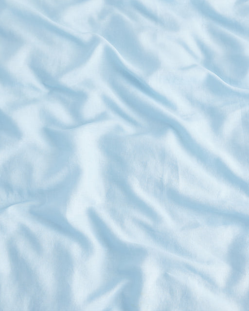 The Coast 100% French Flax Linen Bedding Set from Bed Threads features light blue linen with gentle wrinkles for a soft, textured look—perfect for effortlessly adding charm to your space.