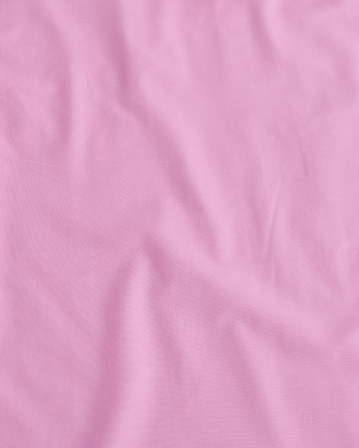 A close-up of the Bed Threads Bubblegum Organic Cotton Flat Sheet shows gentle wrinkles and a smooth, breathable texture—ideal for soft, comfortable bedding.