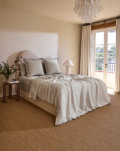 The Bed Threads Oatmeal & Charcoal 100% French Flax Linen Swirl European Pillowcases (Set of Two) add a soft, neutral touch to the bed, complementing a matching headboard and sheet for a cozy, inviting feel. - view