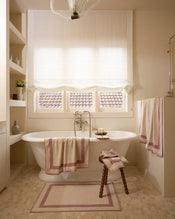 Neutral bathroom with freestanding bath tub and cotton terry towels in a creme colour with lavender border. - view