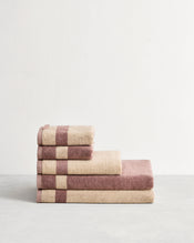Stack of cotton terry towels in reversible colours lavender and creme. - view