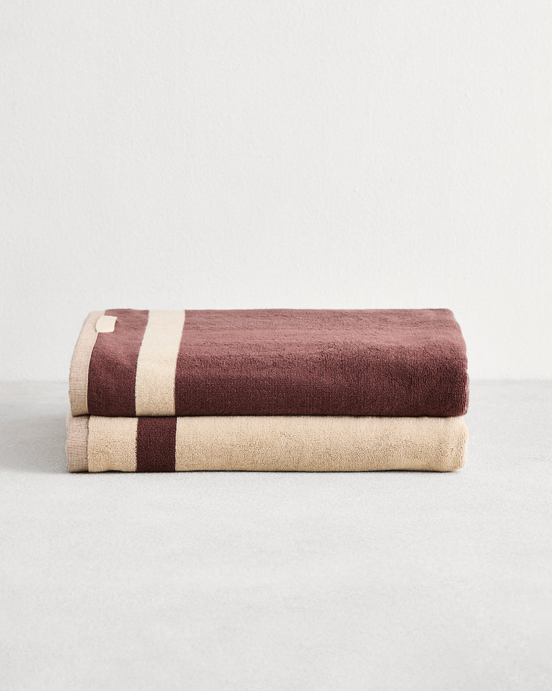 Stack of two cotton terry bath sheeets in reversible colours creme and cacao.