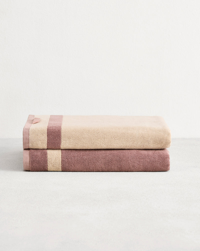Stack of two cotton terry bath sheets in reversible colours lavender and creme.