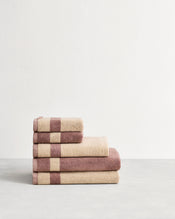 Stack of cotton terry towels in reversible colours lavender and creme. - view