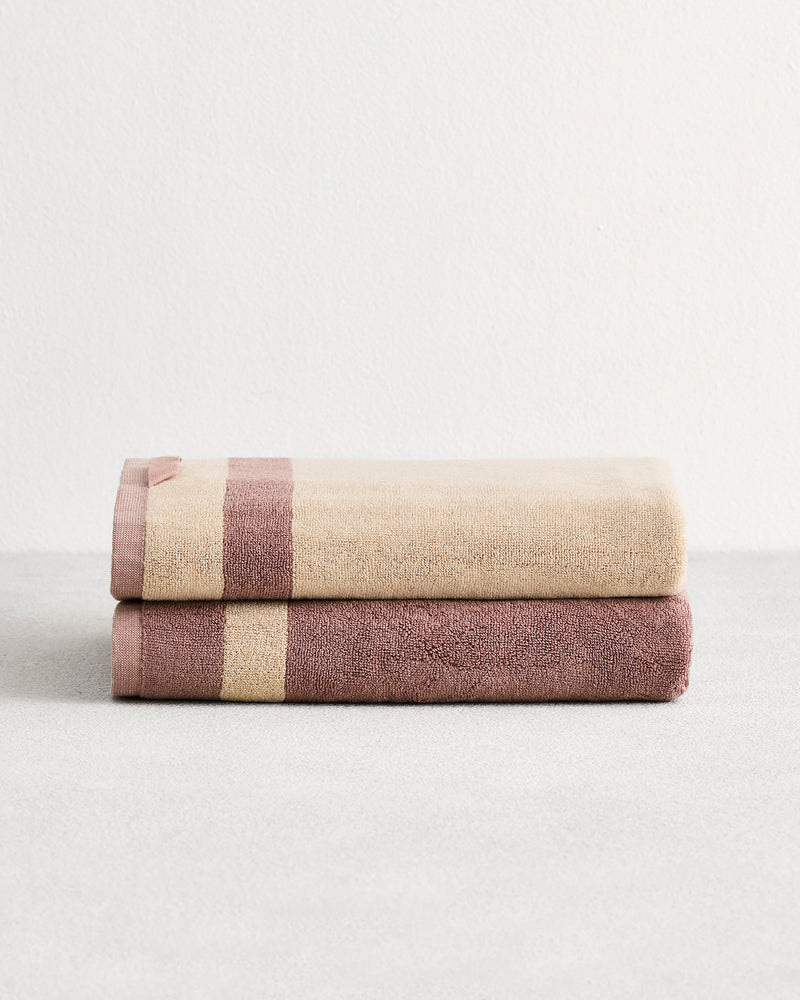 Stack of two cotton terry towels in reversible colours lavender and creme.