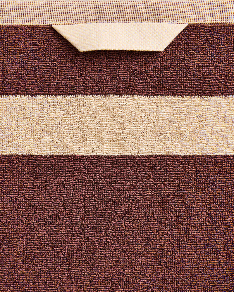 Close-up of a cotton terry hand towel in a cacao colourway with a creme border.
