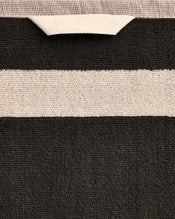 Close-up of a cotton terry towel in a charcoal colourway with an oatmeal border. - view