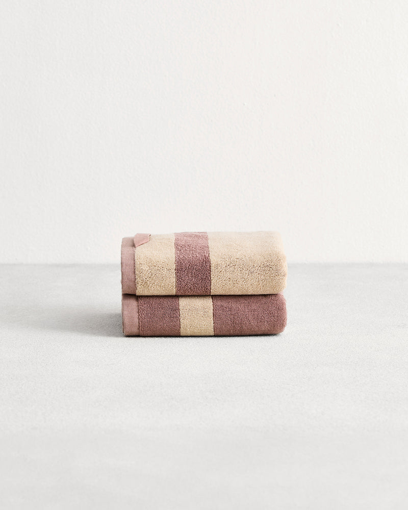 Stack of cotton terry hand towels in reversible colours lavender and creme.