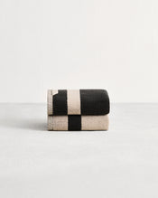 Stack of two cotton terry hand towels in reversible colours oatmeal and charcoal. - view
