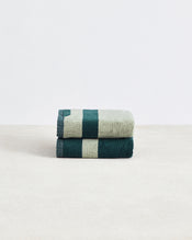 A set of two Forest & Sage Two-Toned 100% Cotton Terry Hand Towels by Bed Threads, with a geometric pattern, are stacked on a light surface against a plain white background. - view