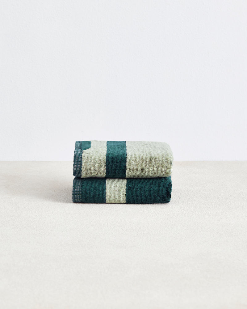 A set of two Forest & Sage Two-Toned 100% Cotton Terry Hand Towels by Bed Threads, with a geometric pattern, are stacked on a light surface against a plain white background.