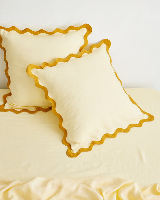 The Bed Threads Limoncello & Turmeric 100% French Flax Linen Scalloped European Pillowcases (Set of Two) add a soft texture and stylish wavy trim, perfect for enhancing your bedroom décor.